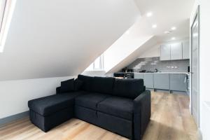 德比1BR Derby City Centre Flat 5 - Charnwood Flat的一间带黑色沙发的客厅和一间厨房