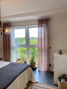 哥德堡Villalägenhet i Askim med havsutsikt的卧室设有大窗户和一张床