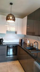 切申Apartament Azul的厨房配有白色橱柜、水槽和灯