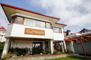 瓦尔迪维亚Hotel Costanera - Caja Los Andes的白色的建筑,旁边标有标志