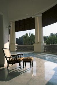瓦拉纳西纳德萨泰姬陵酒店&度假村的一个带椅子的房间和一个游泳池