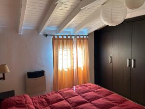 图努扬Dos Aguas的一间卧室设有红色的床和窗户。