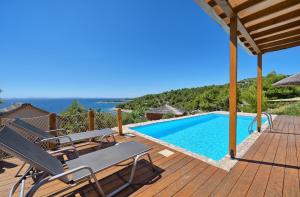 穆泰尔岛Golden Haven Luxe Glamp Resort的木制甲板设有游泳池和桌椅