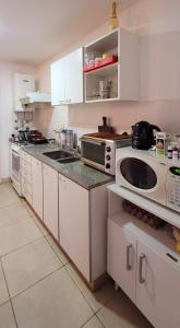 埃塞萨"Valentino hostel"的厨房配有白色橱柜和微波炉