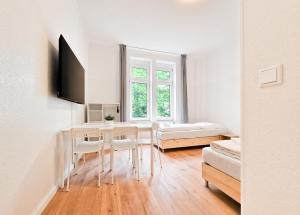 杜伊斯堡RAJ Living - 3 and 4 Room Apartments的客厅配有桌椅和1张床