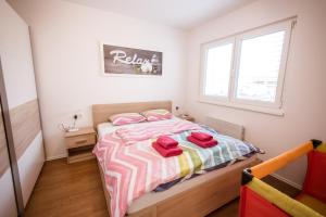 摩拉瓦托普利采Apartma Sofija, Moravski Dvori的一间卧室配有一张带红色毛巾的床