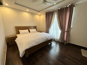 拉合尔2 Bed Apartment near Gulberg的一间卧室设有一张床和一个窗口