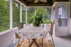 坎伯兰Cumberland Cottage with Screened Porch and Fire Pit!的坐在门廊上的桌子和盆栽植物