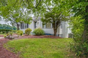 坎伯兰Cumberland Cottage with Screened Porch and Fire Pit!的院子里有树的白色房子