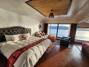 普诺Casitas del Titicaca Peru的一间卧室设有一张大床和一个大窗户