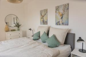 巴特萨尔茨乌夫伦Luxus Apartment Bad Salzuflen的一间卧室配有带枕头和镜子的床