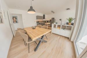 巴特萨尔茨乌夫伦Luxus Apartment Bad Salzuflen的厨房以及带木桌和椅子的用餐室。