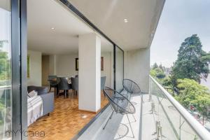 墨西哥城3 Bedrooms Apartment with Panoramic Terrace的客房设有带椅子的阳台。