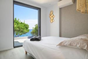 Saint-AntoineProche Monaco, vue mer, accès plage et jardin privatif的一间卧室设有一张床和一个大窗户