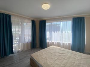 圣弗拉斯MARINA BAY 23 Sveti Vlas Beach的一间卧室配有蓝色窗帘、一张床和窗户