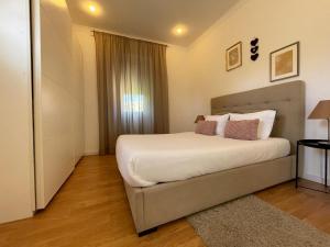 波尔图Burgães II Apartment的卧室配有一张带白色床单和枕头的大床。