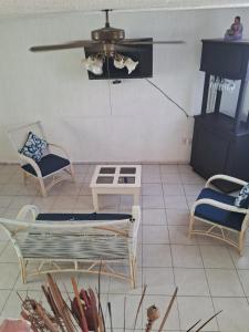 CoyucaCasa Laguna的客厅配有椅子和吊扇