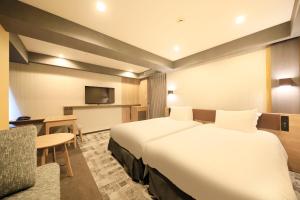 成田成田Richmond酒店的酒店客房带一张大床和一把椅子