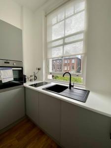 伦敦Studio for 3 near Regents Park n5的厨房设有水槽和窗户。