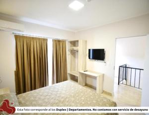 伊瓜苏港Z Hotel Boutique的一间卧室配有一张床和一台电视。