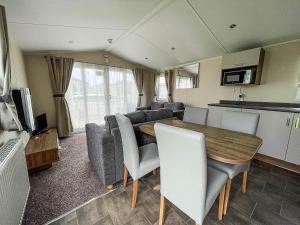 大雅茅斯Superb 8 Berth Caravan For Hire At A Great Holiday Park In Norfolk Ref 50007a的厨房以及带桌椅的起居室。