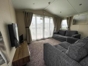 大雅茅斯Superb 8 Berth Caravan For Hire At A Great Holiday Park In Norfolk Ref 50007a的带沙发和电视的客厅