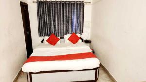 拉杰果德OYO Flagship Hotel Capital的小卧室配有红色枕头的床