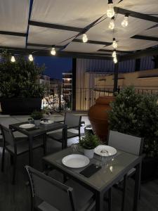 布林迪西Terrazza Poesìa的屋顶餐厅,配有桌椅