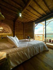 萨兰托Hakuna Matata Glamping timon的一张大床,位于带大窗户的房间里