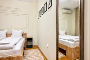 大特尔诺沃ApartPro Apartments, Veliko Tarnovo的配有2张床的客房内的镜子