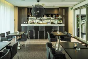 米哈洛夫采木森酒店的一间带桌椅的餐厅和一间酒吧