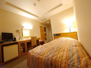 福井Hotel Fukui Castle - Vacation STAY 58682v的酒店客房配有一张床、一张书桌和一台电视。
