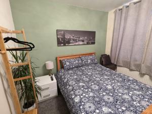 ShinfieldLarge Cosy Room to Stay in South Reading的一间卧室配有一张带蓝色棉被的床