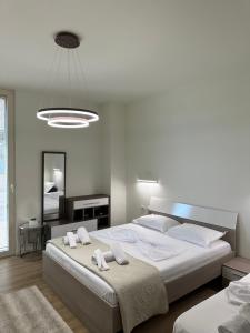 德尔米Green Coast Resort Vila 143B的一间白色卧室,配有两张床和镜子