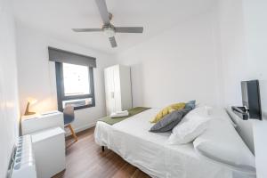 雷乌斯ApartamentosDnord的白色的卧室设有床和窗户