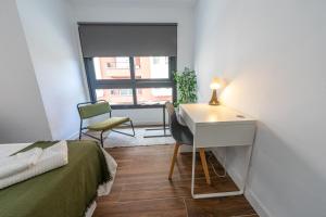 雷乌斯ApartamentosDnord的一间卧室配有一张床、一张书桌和一个窗户。