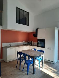 Saint-AlbanL'inattendu的厨房配有木桌和蓝色椅子