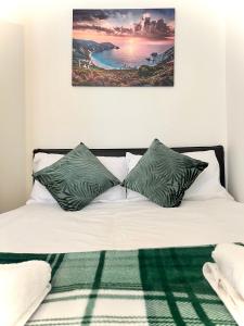 伦敦White chapel Holiday 2 Bedroom Apartment的一张带绿色和白色枕头的床