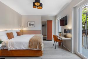 阿斯科纳Living Ascona Boutique Hotel - Smart Hotel的一间卧室配有一张床、一张书桌和一个窗户。