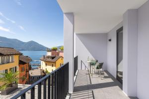 阿斯科纳Living Ascona Boutique Hotel - Smart Access的阳台享有水景和建筑景观。