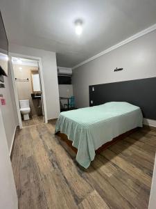 弗洛里亚诺波利斯Cobertura的一间卧室配有一张带绿毯的床