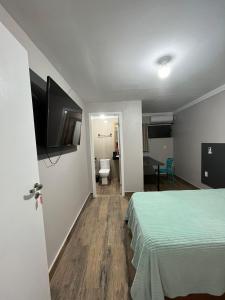 弗洛里亚诺波利斯Cobertura的配有一张床和一台平面电视的酒店客房