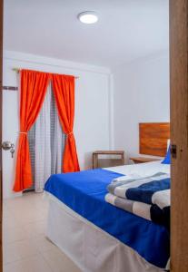 RuiosucioSecretos del Eden的一间卧室设有蓝色的床和窗户。