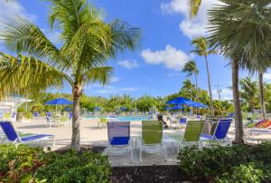 塔维涅2306 Ocean Pointe的游泳池拥有蓝色和绿色的椅子和棕榈树