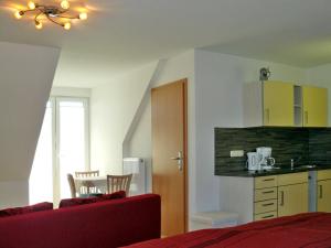 KröslinFerienwohnungen mit Balkon的一间卧室配有一张床铺和一张桌子,还设有一间厨房