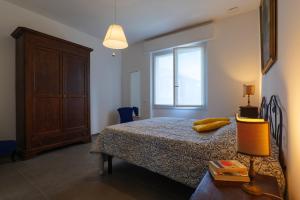 韦尔巴尼亚Casa Augusta的一间卧室配有带梳妆台和窗户的床。