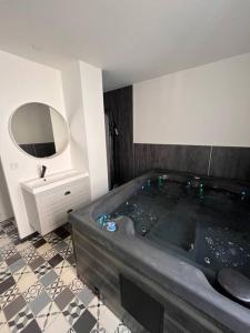 阿夫朗什Coin de paradis avec spa illimité en plein centre Avranches的一间带大浴缸和镜子的浴室