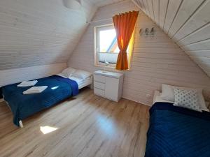 尼彻兹Błękitne Zamorze的一间卧室设有两张床和窗户。
