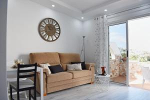 阿德耶Ke Casetta Tenerife Anna Apartment的客厅配有沙发和墙上的时钟
