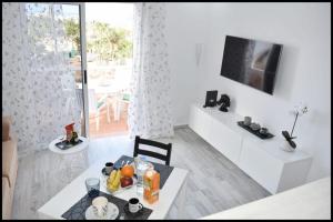 阿德耶Ke Casetta Tenerife Anna Apartment的白色的客厅配有桌子和电视。